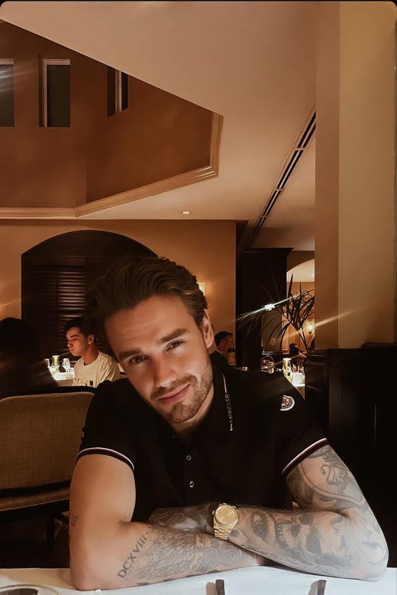 a man sitting at a table with his arms crossed in front of him and looking off to the side