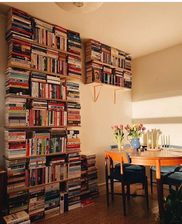 a dining room table surrounded by bookshelves filled with books