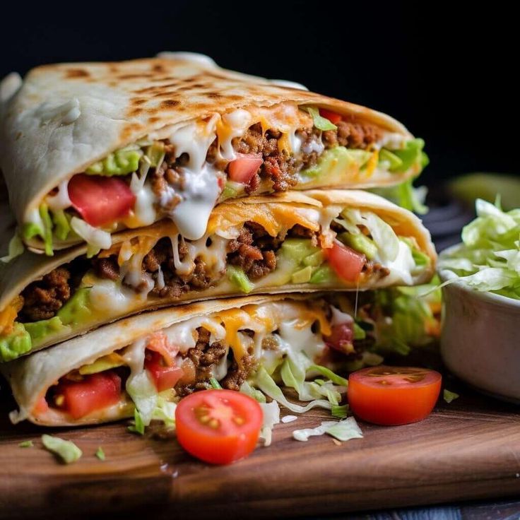 two quesadillas stacked on top of each other with lettuce and tomatoes