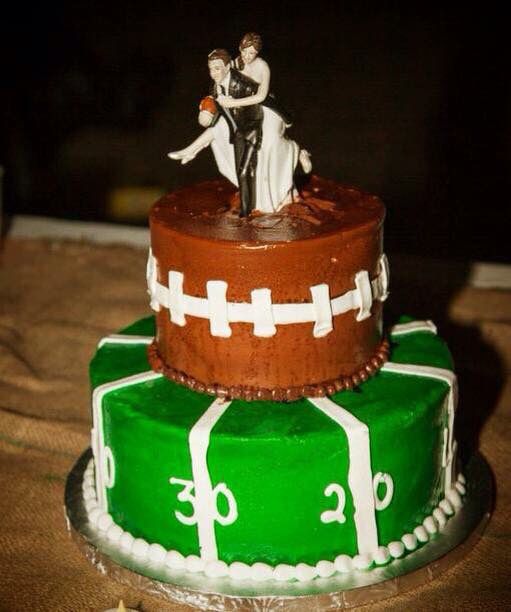 two tiered wedding cake decorated with footballs and bride and groom figurines