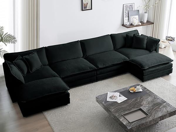 a living room with a large black sectional couch