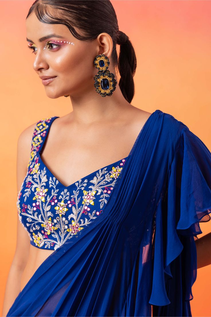 Editor's Note Elevate your style with an embellished choli, perfectly paired with a pre-stitched ruffle sari. This ensemble exudes charm and grace, combining intricate detailing with the ease of a pre-stitched sari for a mesmerizing and fashionable look. Fabric: Georgette, satin lining Color: Blue Components: Sari and blouse Occasion: Festive Note: Product colour may slightly vary due to photographic lighting sources Care: Dry clean only About the Designer Seema Thukral presents a collection of Seema Thukral, Blouse Yoke, Personal Shopping Service, Electric House, Photographic Lighting, Personal Shopping, Elevate Your Style, Electric Blue, Chic Outfits