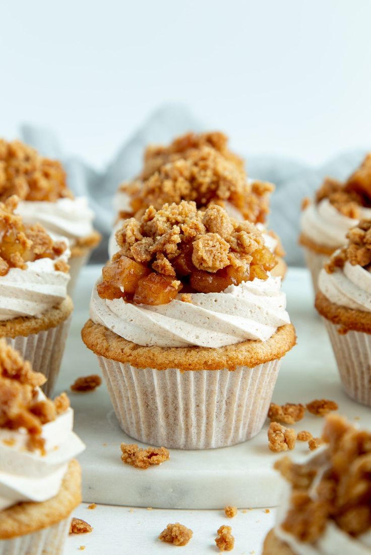 several cupcakes with white frosting and crumbs