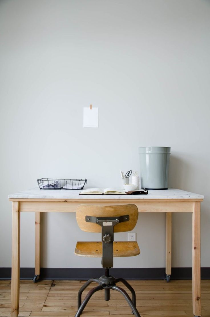 a desk with a chair and a basket on it