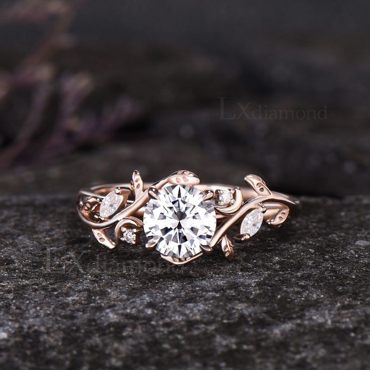 a close up view of a diamond ring on top of a rock with leaves around it