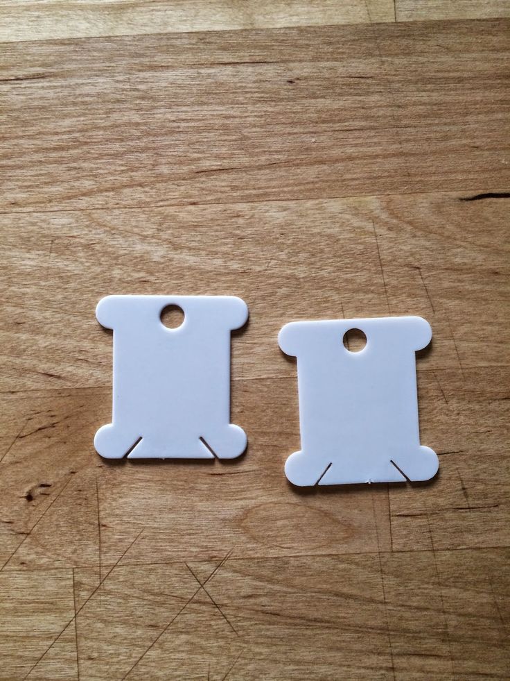 two white tags sitting on top of a wooden table