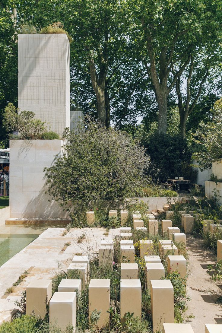 the garden is surrounded by concrete blocks and trees