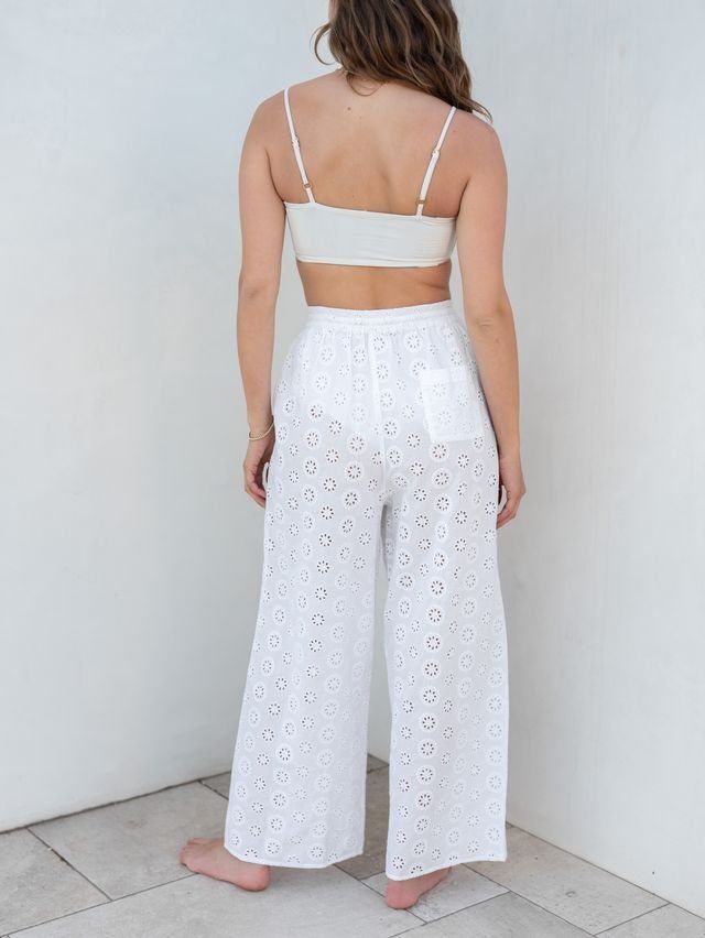 Our Daisy Eyelet Coverup comes in pants now too. This coverup features a delicate daisy eyelet pattern, a relaxed elastic waist which makes them perfect to throw over your favorite swimsuit. From the beach to the pool deck or right on to lunch in town, these pants are the coverup of the season. Beachy Pants For Poolside, Beachy Poolside Pants, White Summer Pants For Poolside, White Beachwear Pants With Elastic Waistband, Summer White Pants For Poolside, White Pants For Poolside And Beach Season, Spring Beachwear Bottoms For Day Out, Beachwear Bottoms For Spring Day Out, Spring Beachwear Pants For Day Out