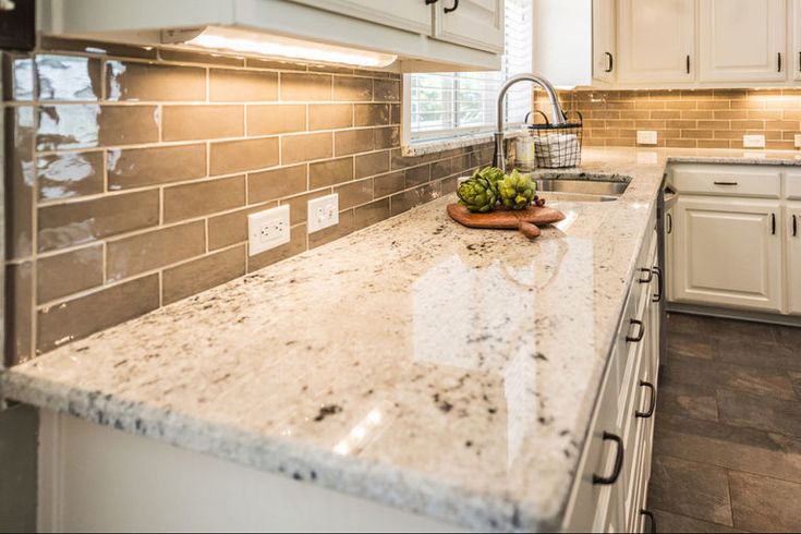 an image of a kitchen setting with granite counter tops and tile backsplashes