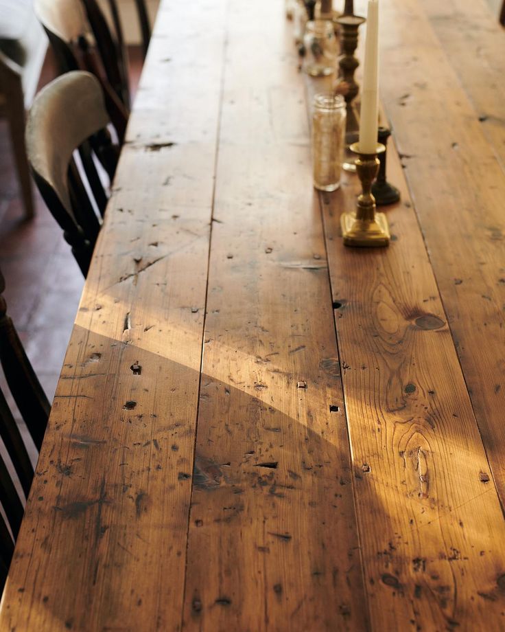 a long wooden table with candles on it