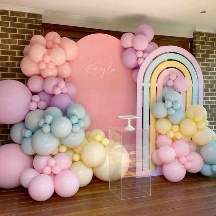 balloons are floating in the air near a wall with a arch and doorway on it