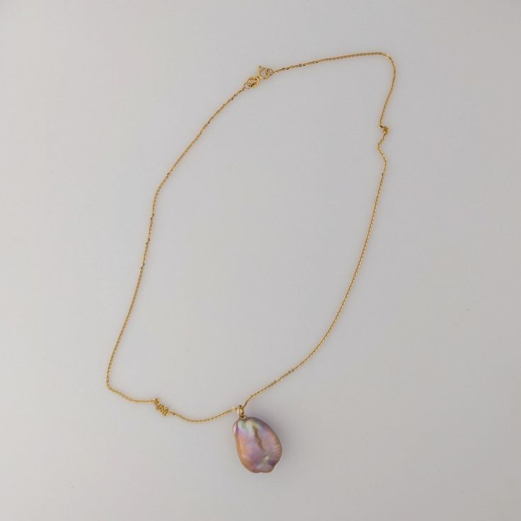 This premium-quality Chinese Freshwater pearl pendant features a bead-nucleated pearl affixed to an 18K yellow gold bail. The pearl has an organically smooth baroque shape, measuring 17-18 by 23mm and weighing 5.2g. If paired with an optional chain, the total weight comes to 6.7g. Displaying a naturally metallic blend of purple, pink, and peach hues, accented by green and pink overtones, the pearl has a luminous glow. The pearl's surface is clear, which allows its stunning beauty to be fully app Briolette High Luster Pearl Necklace Gift, High Luster Briolette Pearl Necklace As Gift, High Luster Briolette Pearl Necklace For Gift, Luxury Drop Pearl Necklace For Gift, Handmade Gold Pearl Necklace With Briolette, Gold Tahitian Pearl Pendant Necklace, Yellow Gold Pearl Necklace With High Luster Baroque Pearls, Yellow Gold High Luster Baroque Pearl Necklace, Baroque Pearl Necklace With Teardrop Pendant