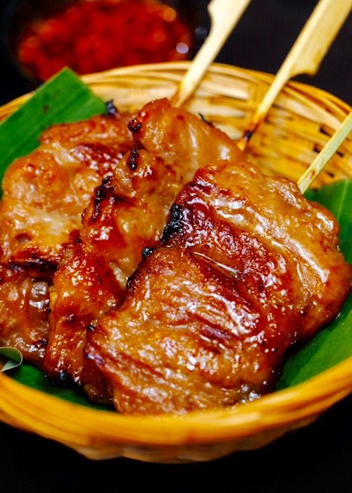 two pieces of meat in a basket with chopsticks