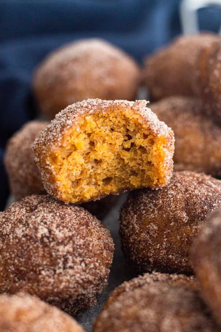 pumpkin spice donut muffins stacked on top of each other with the bite taken out