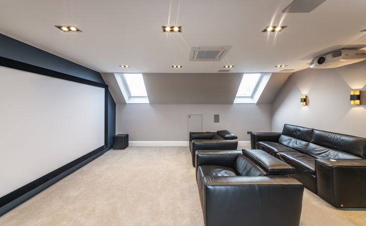 an empty home theater with black leather couches