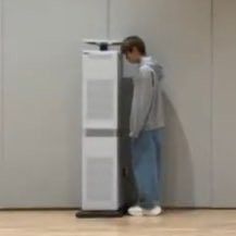 a man leaning against a tall white refrigerator