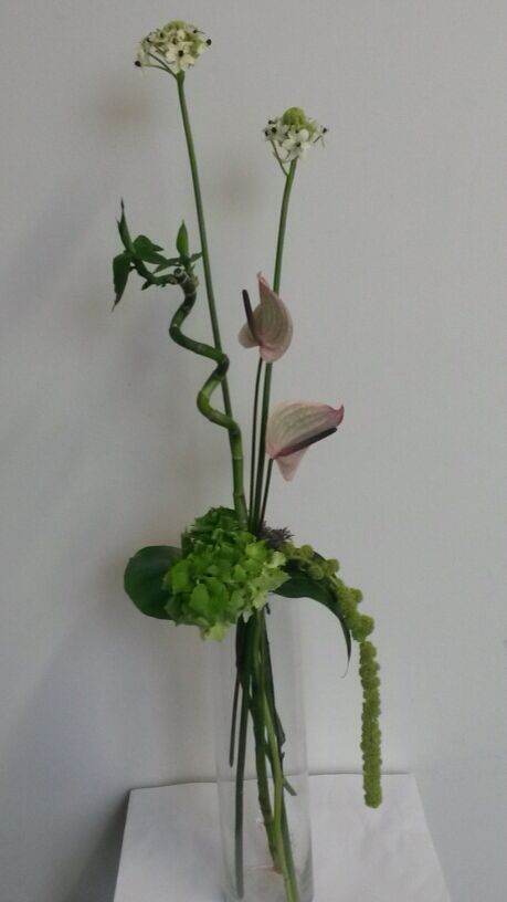 a vase filled with flowers sitting on top of a white tablecloth covered floor next to a wall