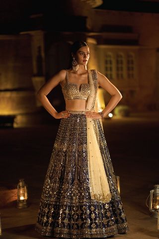 This lehenga set features all over mirror work and is paired with a fully embroidered... Wedding Outfits Bride And Groom, Wedding Outfits Bride, Ethnic Wedding Outfits, Phir Bhi Dil Hai Hindustani, Navy Mirror, Navy Blue Lehenga, Lehenga Ideas, Seema Gujral, Gold Lehenga