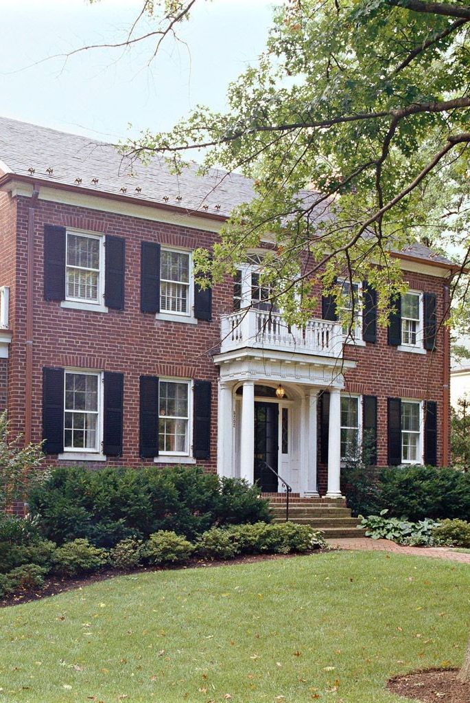 a large brick house with white trim and black shutters