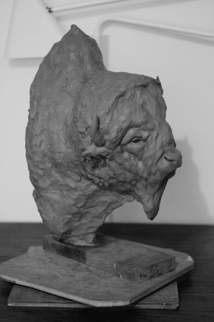 a black and white photo of a sculpture of a bear's head on a table