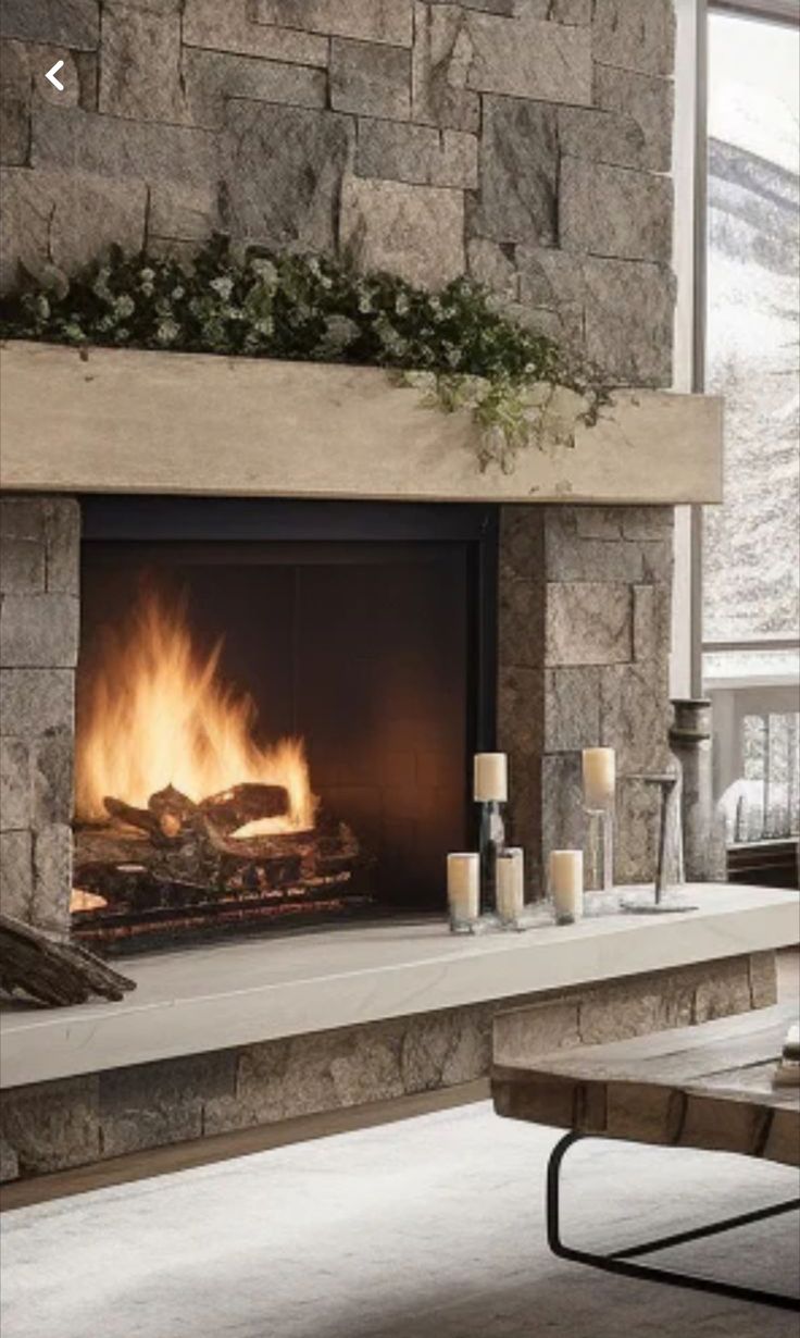 a living room with a fire place in the center and candles on the mantle next to it