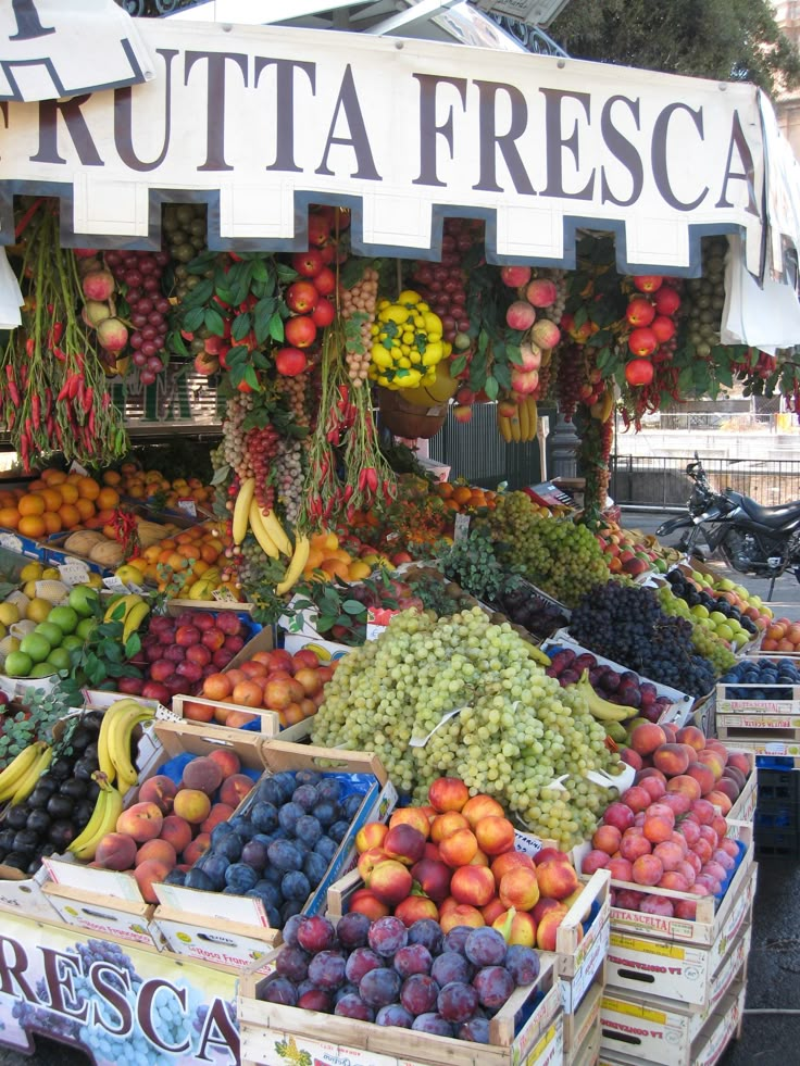 an outdoor fruit stand with various fruits and vegetables