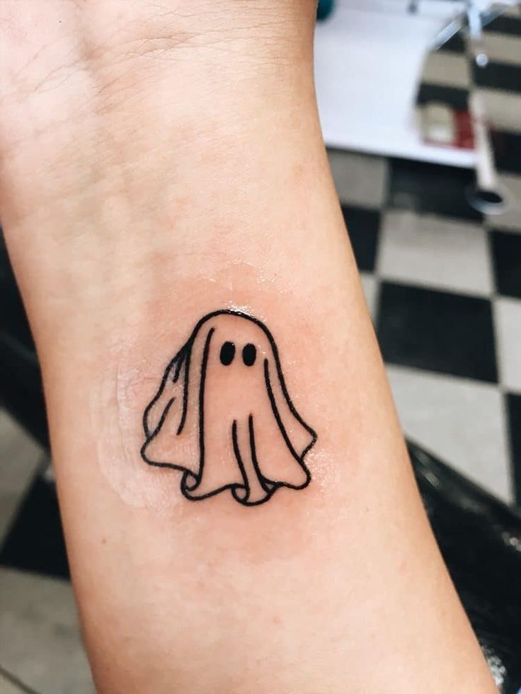 a small ghost tattoo on the wrist