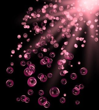 pink bubbles floating in the air on a black background with light coming from behind them