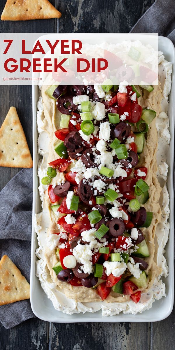 a platter filled with greek dip and pita bread, topped with olives