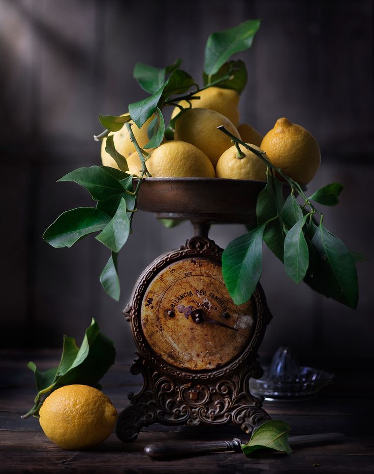 a clock with lemons in it sitting on a table