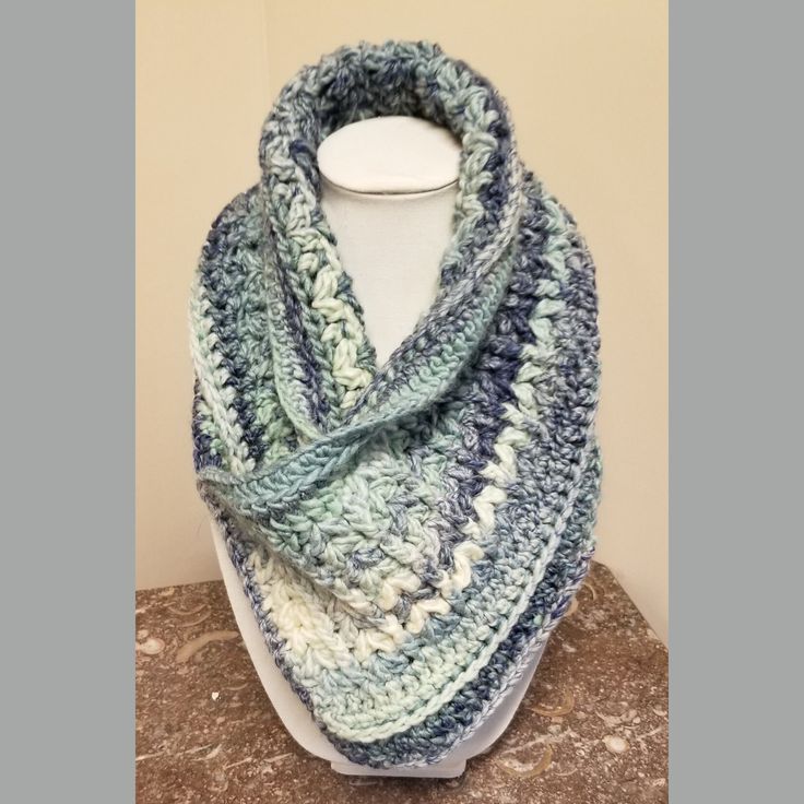 This handcrafted neck-warmer scarf has been expertly knitted using variegated blue yarn. It can be folded in a variety of different ways creating an almost endless array of different looks. Blue Knitted Yarn Scarves, Blue Knitted Yarn Scarf, Blue Knitted Scarves One Size, Blue Knitted Scarf, One Size, Blue Knitted Scarf One Size, Blue Hand Knitted Scarf, Blue Knitted One-size Scarf, Cozy Blue Scarf One Size, Blue Crochet Scarves For Winter