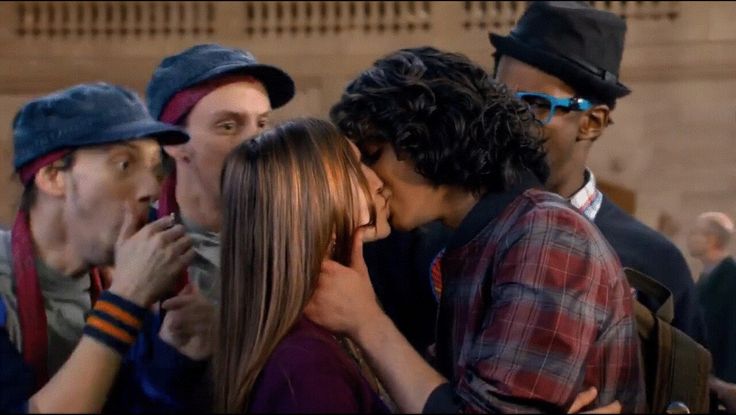 group of people kissing each other in front of a crowd