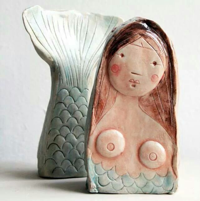 a ceramic figurine with a woman's head in the shape of a fish