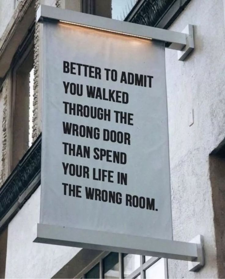 a sign on the side of a building that says, better to admit you walked through the wrong door than spend your life in the wrong room