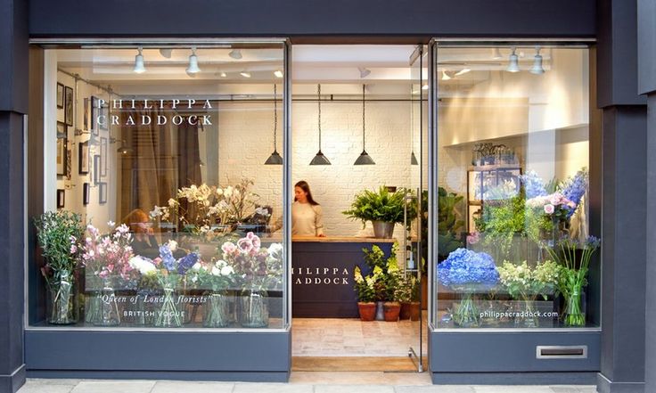 an image of a flower shop with flowers in the window and on the front door