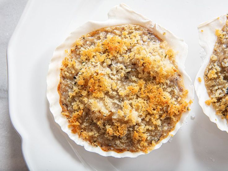 two baked desserts on a white plate with crumbs