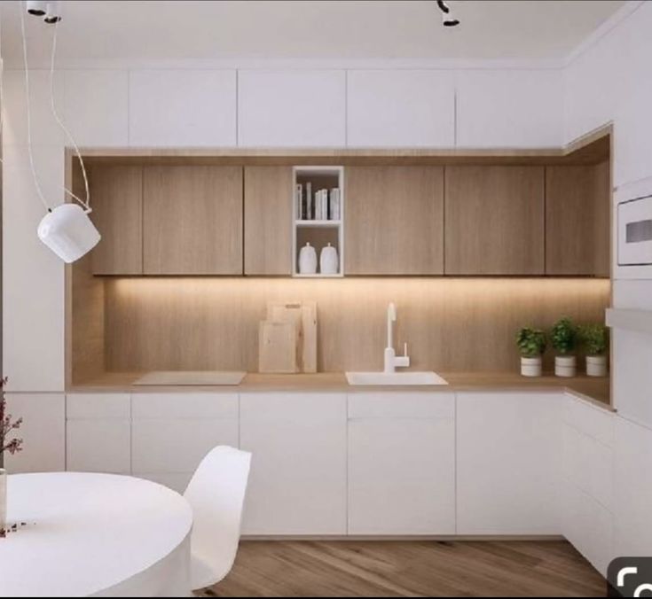 a white table and chairs in a room with wood flooring on the wall behind it