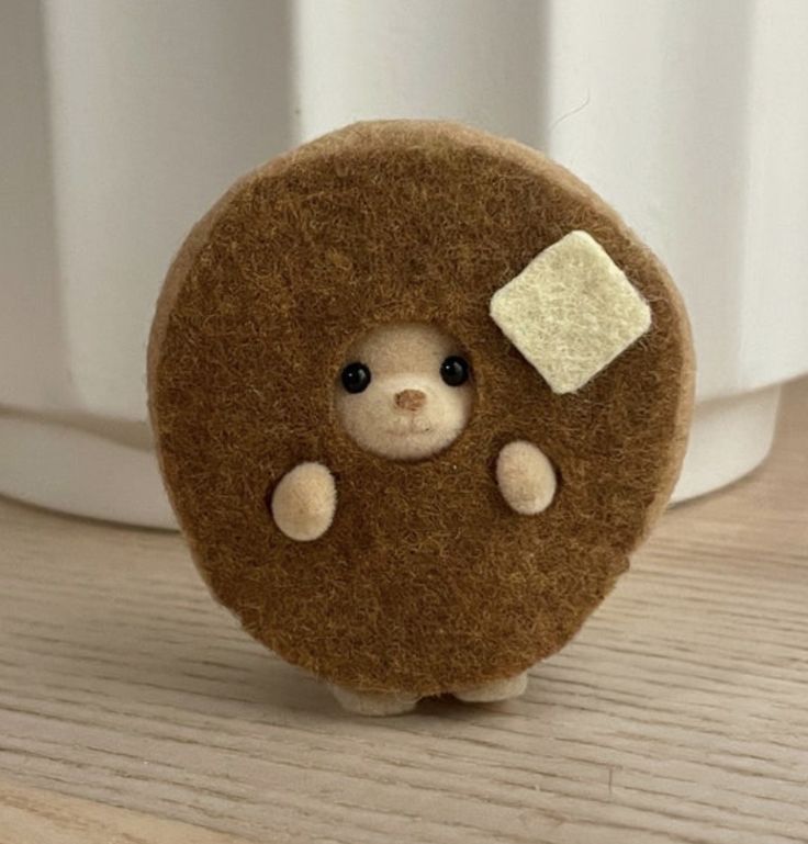 a brown teddy bear with white patches on it's eyes