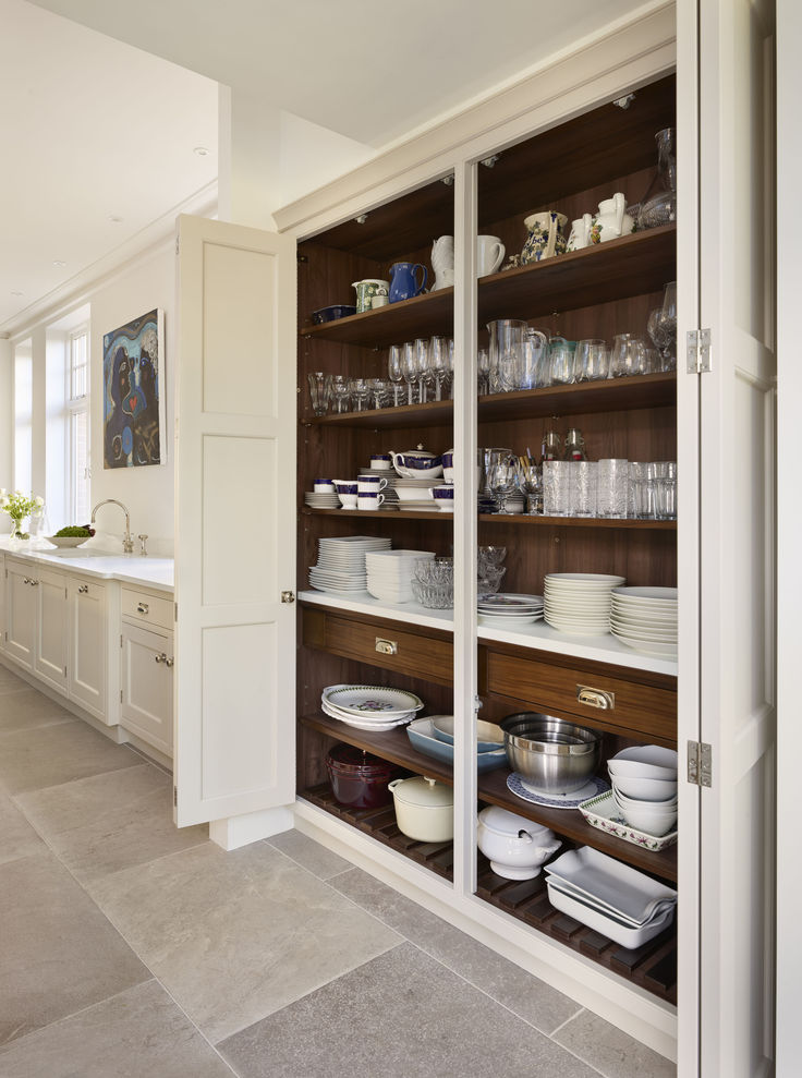 a kitchen filled with lots of white dishes and cupboards next to a counter top