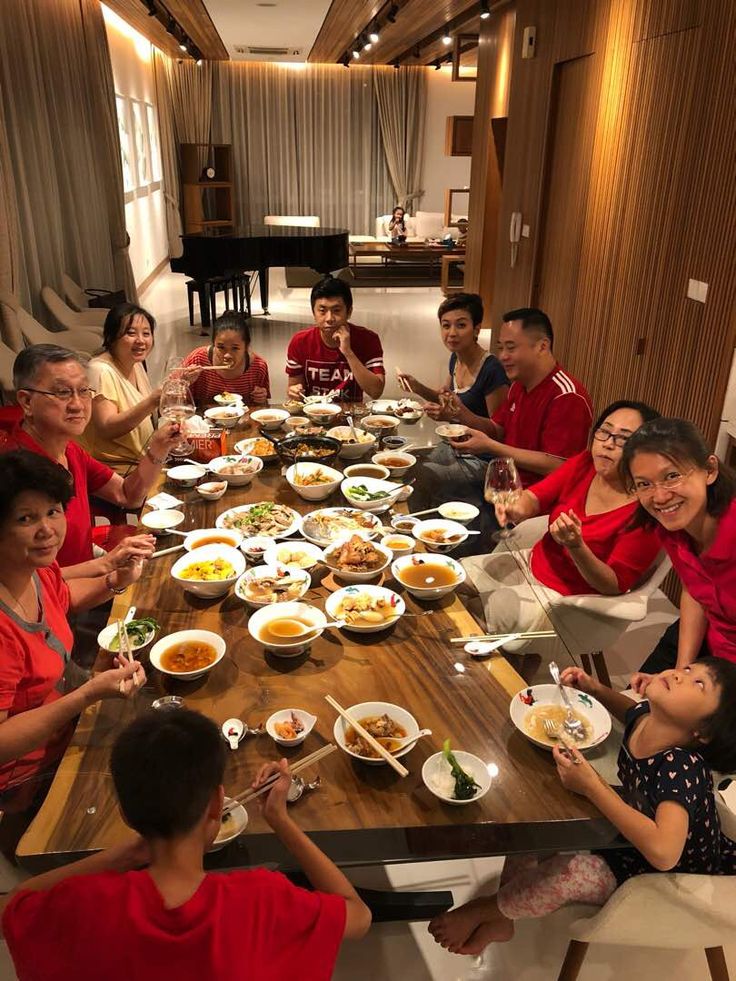 a group of people sitting around a table with food in front of them on it