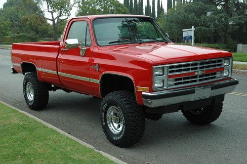 a red pick up truck is parked on the street