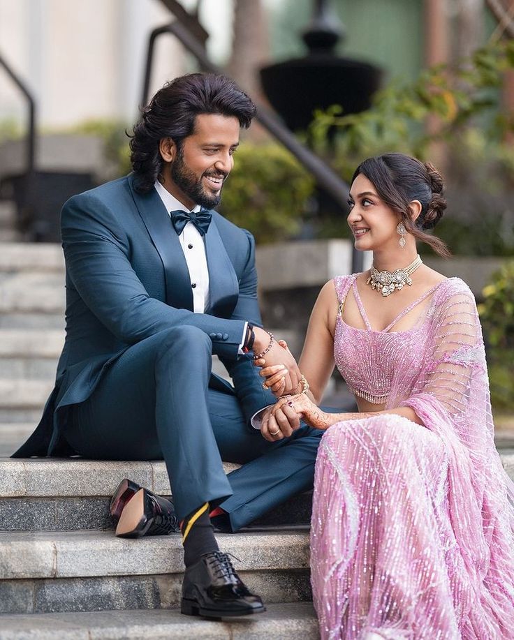 a man in a tuxedo sitting next to a woman wearing a pink dress