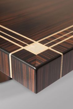 a close up of a wooden table with gold lines on the top and bottom edge