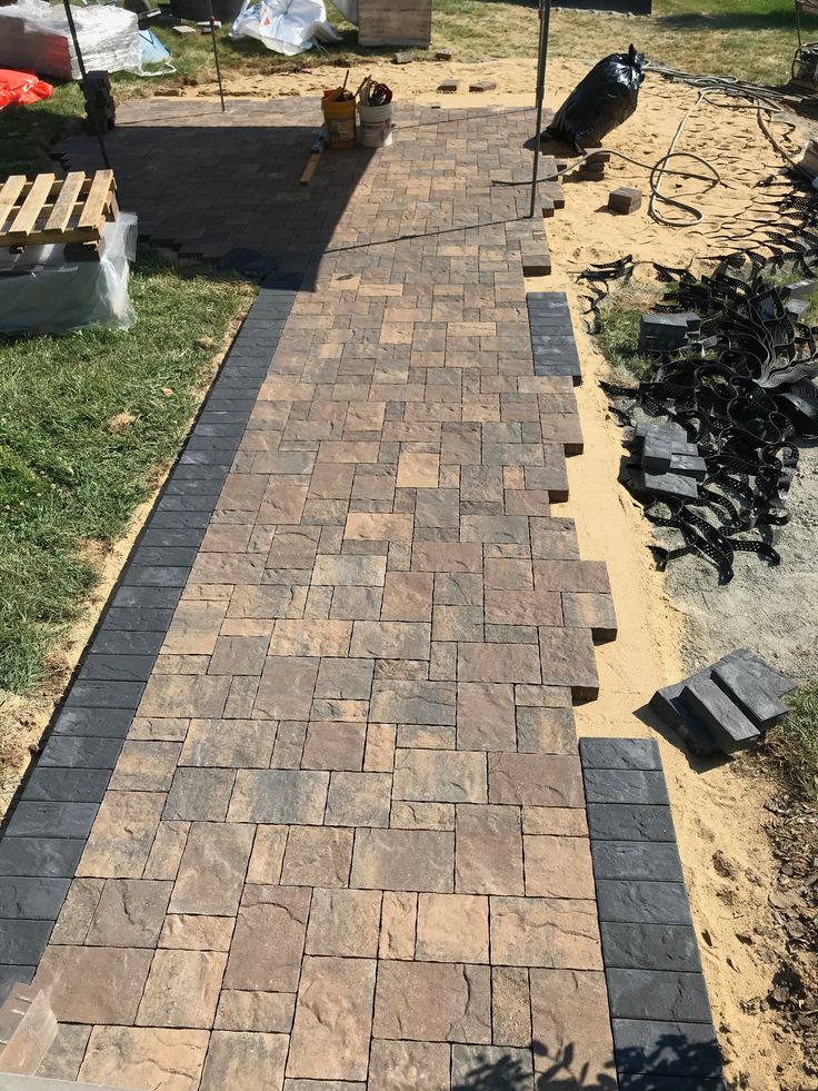 a brick walkway in the middle of a yard