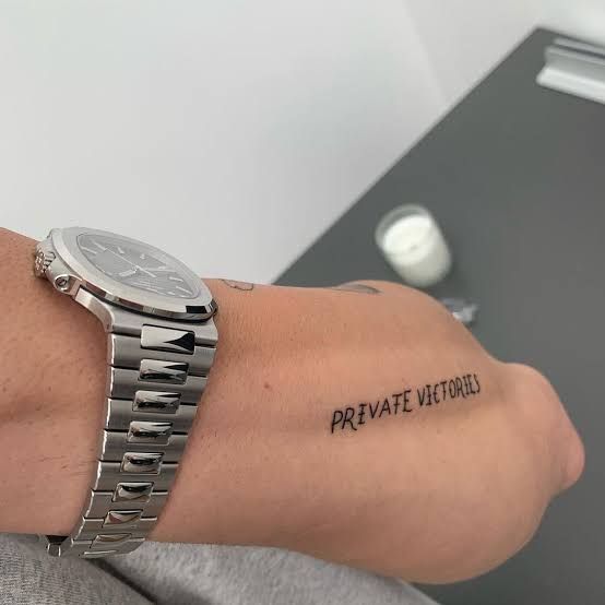 a person with a wrist tattoo that says, private veteran on their left side arm