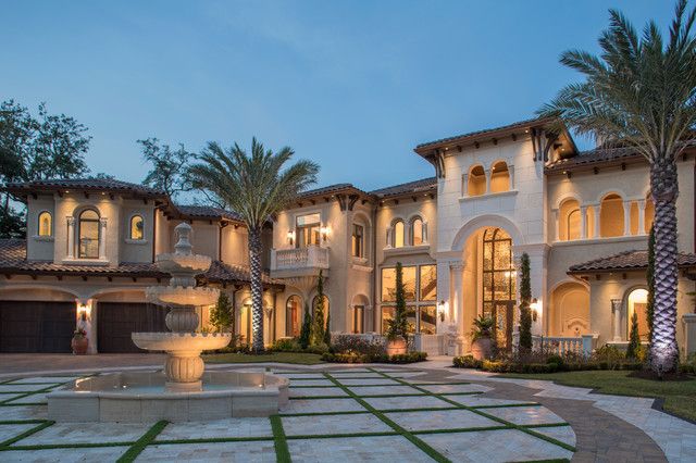 a large house with a fountain in front of it