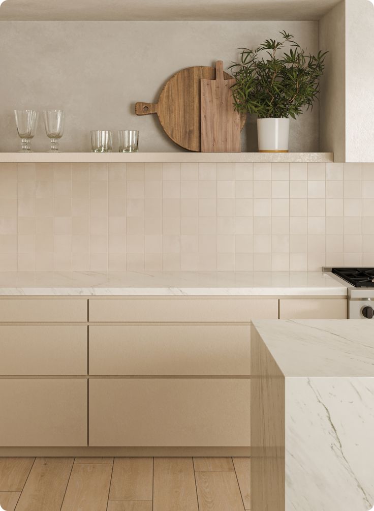 a kitchen with white cabinets and marble counter tops