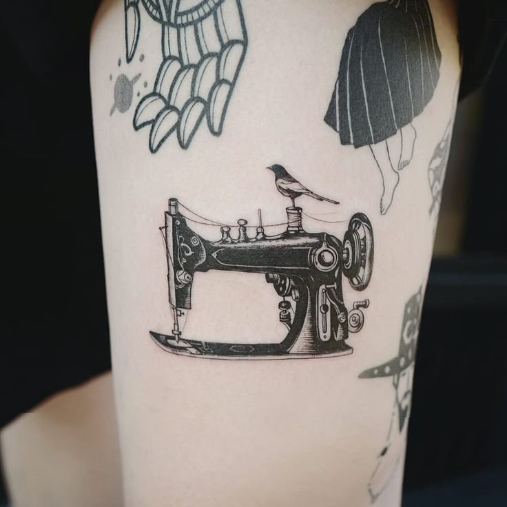 a tattoo with a sewing machine on it