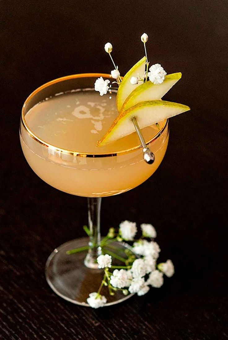 an apple martini garnished with white flowers