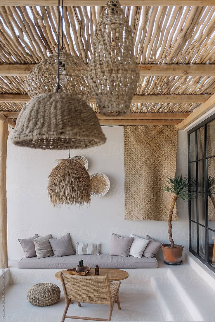 a living room filled with lots of furniture and wicker hanging from the rafters